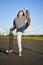 Excited asian girl dancing, standing with skateboard, skating on longboard and shouting carefree