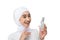 Excited asian hijab girl wearing white dress holding a bottle of serum with hands gesture