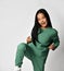 Excited asian preteen girl in green clothing showing yes gesture