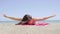 Excited attractive young woman lying on a beach