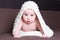 Excited baby girl in white woolen scarf crawling