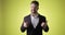 Excited bearded young man in office suit showing thumbs up like gesture.