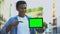 Excited black boy pointing finger at green screen tablet in hand, advertising