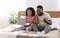 Excited black family expressing happiness, looking at laptop screen