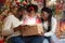 Excited black family of three opening shining Christmas gift box