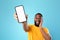 Excited black man presenting smartphone with empty screen, recommending website or ad, blue background, space for mockup