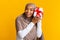 Excited black muslim girl in hijab shaking gift box, guessing present