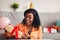 Excited Black Woman Opening Wrapped Birthday Gift Box At Home