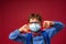 Excited boy in mask, glasses, with school backpack shows gesture of disapproval