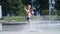 Excited boy of seven years having fun between water jets, in fountain, run around, sprinkle, have fun, have fun, on a