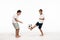 Excited boy showing wow gesture while looking at brother playing with soccer ball