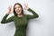 Excited brunette woman giving double OK gesture