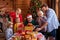 Excited caucasian family give christmas gifts to their cute grandfather