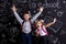 Excited and cheerful schoolkids standing before the chalkboard as a background with a backpack on their backs showing