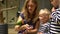 Excited children with mother feeding parrot bird sitting on hand. Gimbal motion