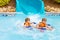 Excited children in water park riding on slide with float