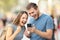 Excited couple receiving good news on line outside