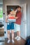 Excited couple stands at the door of a new apartment