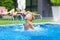 Excited cute boy having fun in pool