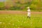 Excited cute boy running blooming field, spring countryside