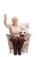 Excited elderly woman with a football sitting in an armchair and