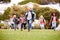 Excited Elementary School Pupils Running Across Field At Break Time