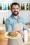 Excited enthusiastic waiter smiling while showing a tasty meal