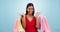 Excited face, woman and shopping bag in studio for fashion, retail deal and financial freedom on blue background