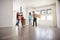 Excited Family Carrying Boxes Into New Home On Moving Day