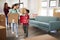 Excited Family Carrying Boxes Into New Home On Moving Day