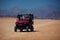 Excited family having a safari tour through the desert in buggy car. thrill adventures