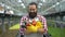 Excited farmer holding handful of fresh harvest, organic vegetables production