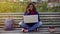 Excited female communicating with boyfriend on mobile phone, studying on bench