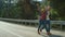 Excited friends hiking mountain road. Backpackers hold text banner on hitchhike.