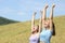 Excited friends raising arms celebrating in a wheat field