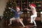 Excited funny kids dancing to music at Xmas tree