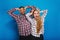 Excited funny young woman with long blonde hair having fun with handsome guy fooling around together on blue background