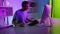 Excited gamer talking team on online stream in home neon cyberspace studio.