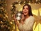 Excited girl with alarm clock at home in Christmas decorations