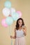 Excited girl with balloons raising wineglass