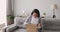 Excited girl customer open cardboard box satisfied sit on sofa