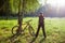 Excited girl cyclist standing in sunny park