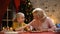 Excited girl decorating Xmas cookies with granny, family festive traditions