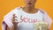 Excited girl drinking beverage from paper cup and holding popcorn bowl, cinema