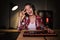 Excited girl gamer sitting at the table, playing online games