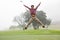 Excited golfer jumping up and smiling at camera