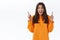 Excited gorgeous girl in orange hoodie scream in excitement and surprise, found cool offer share news with you, pointing