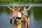 Excited grandfather, father and son are fly fishing on river.