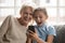 Excited grandmother and granddaughter watch funny video on cell