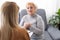 Excited grandmother talking to a psychologist about positive life of pensioner